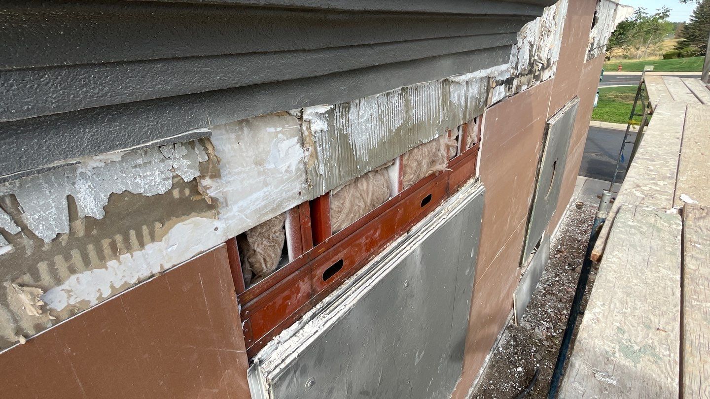 Exposed wall section showing wooden framing and partially removed siding revealing underlying materials in westiminster, co