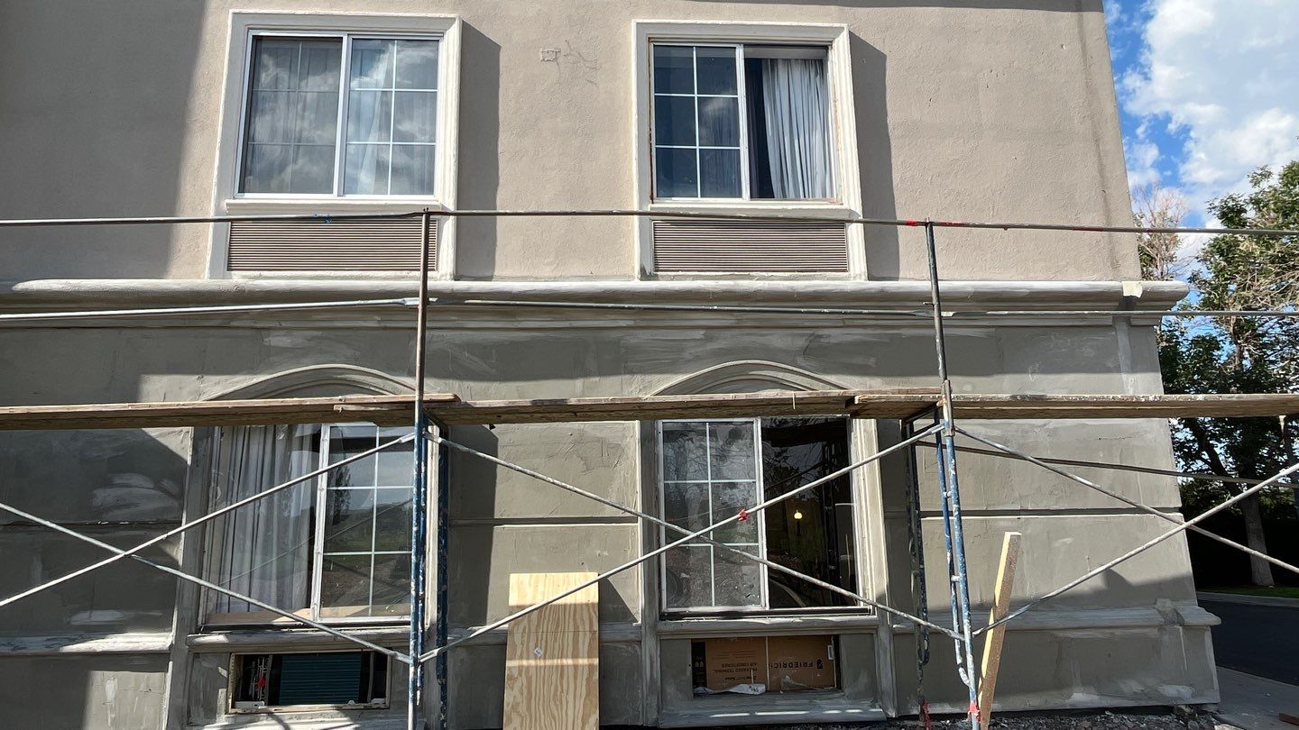 Multi‑story building exterior with scaffolding set up for stucco renovation work westiminster, co